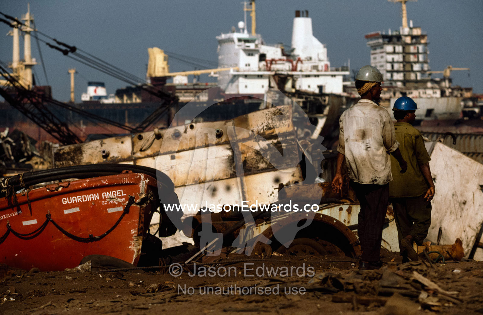 Laborers pass a lifeboat  which will be re-sold or recycled. Alang, India.
