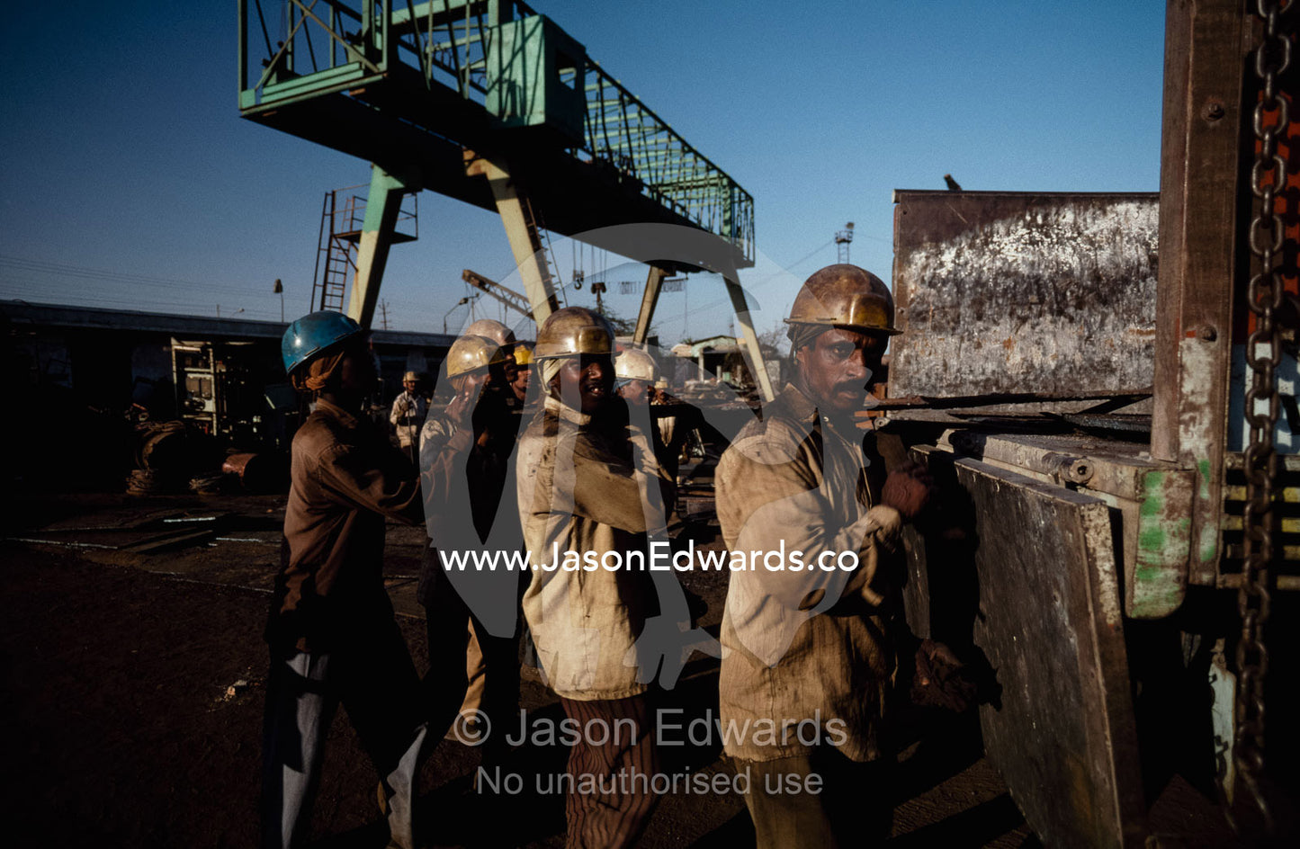 Laborers load sections of steel onto a truck to be sold as scrap. Alang, India.