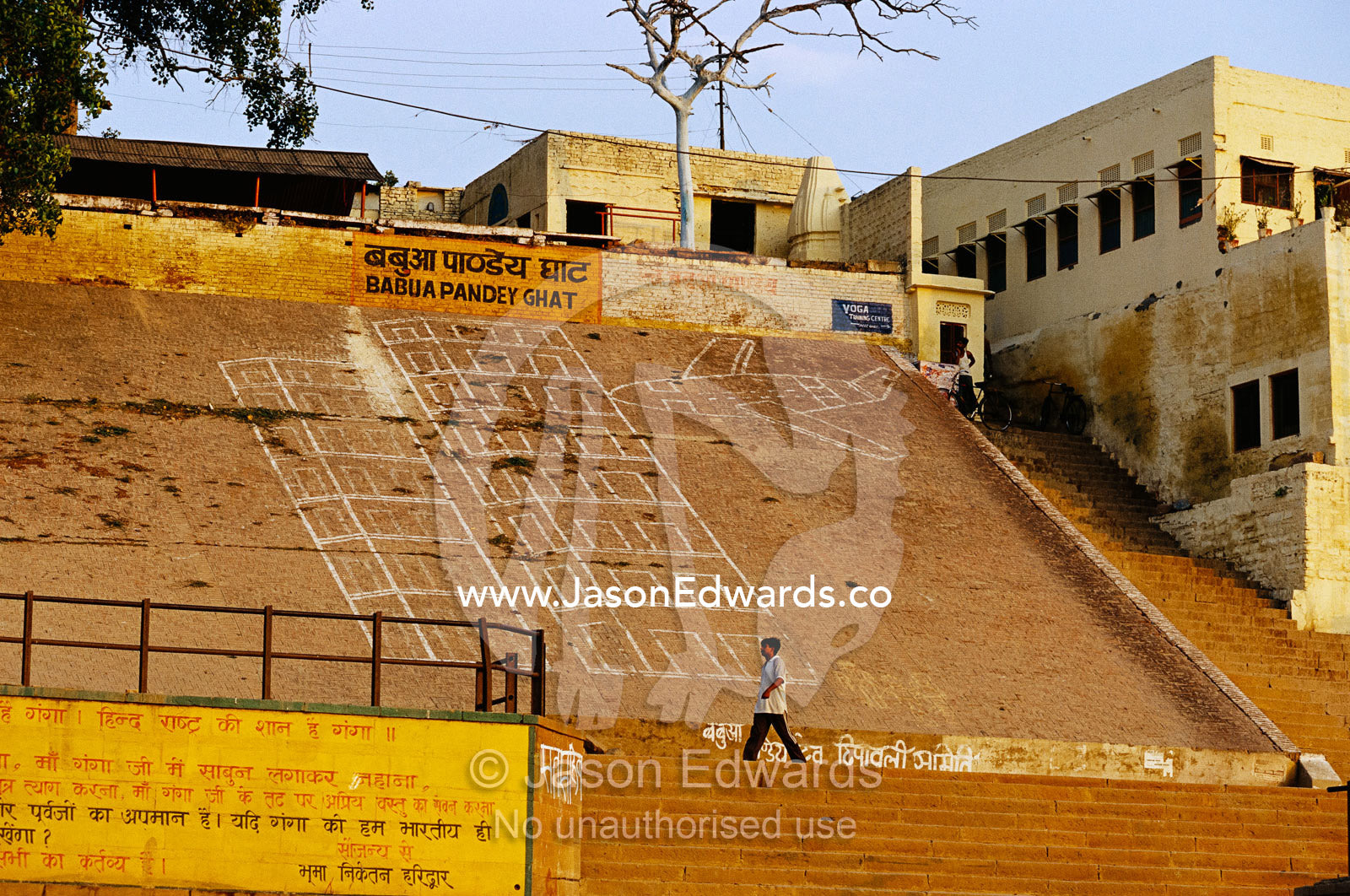 A man walks past 9/11/01 terrorism graffiti on a Ganges river bank. Varanassi, India.