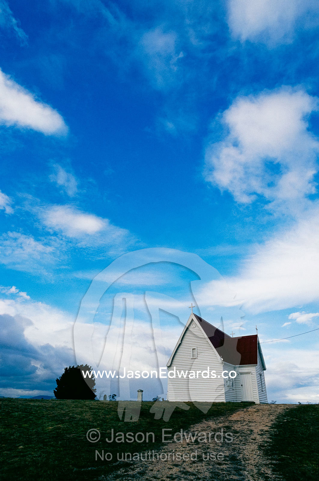 A quaint church under a blue sky with puffy clouds. Cressy, Tasmania, Australia.