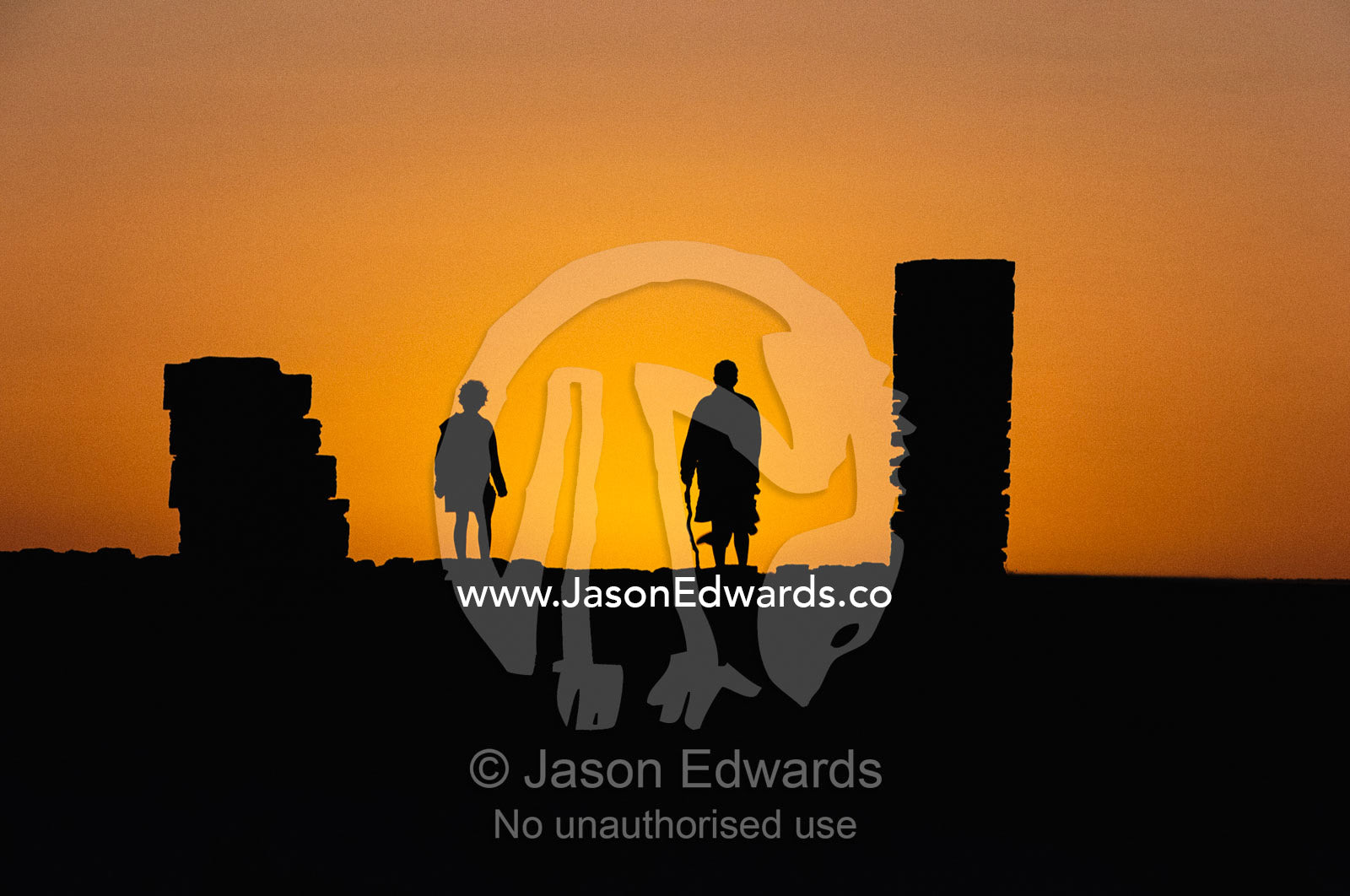 Silhouetted people at sunset at an old desert telegraph station. Eucla, Western Australia.