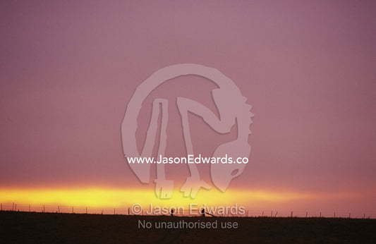Storm clouds break over a farm fence and gate near Bonnie Doon. Bonnie Doon, Victoria, Australia.