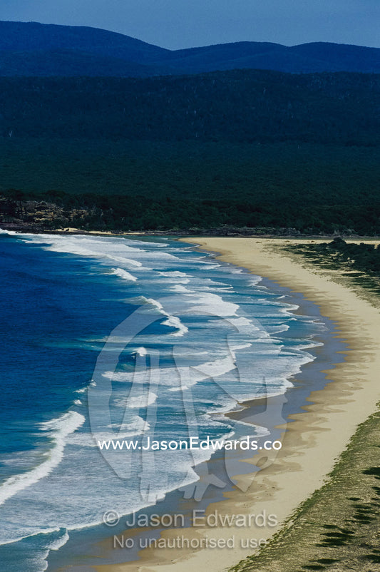 Waves along a pristine beach in Disaster Bay at Ben Boyd National Park New South Wales, Australia.
