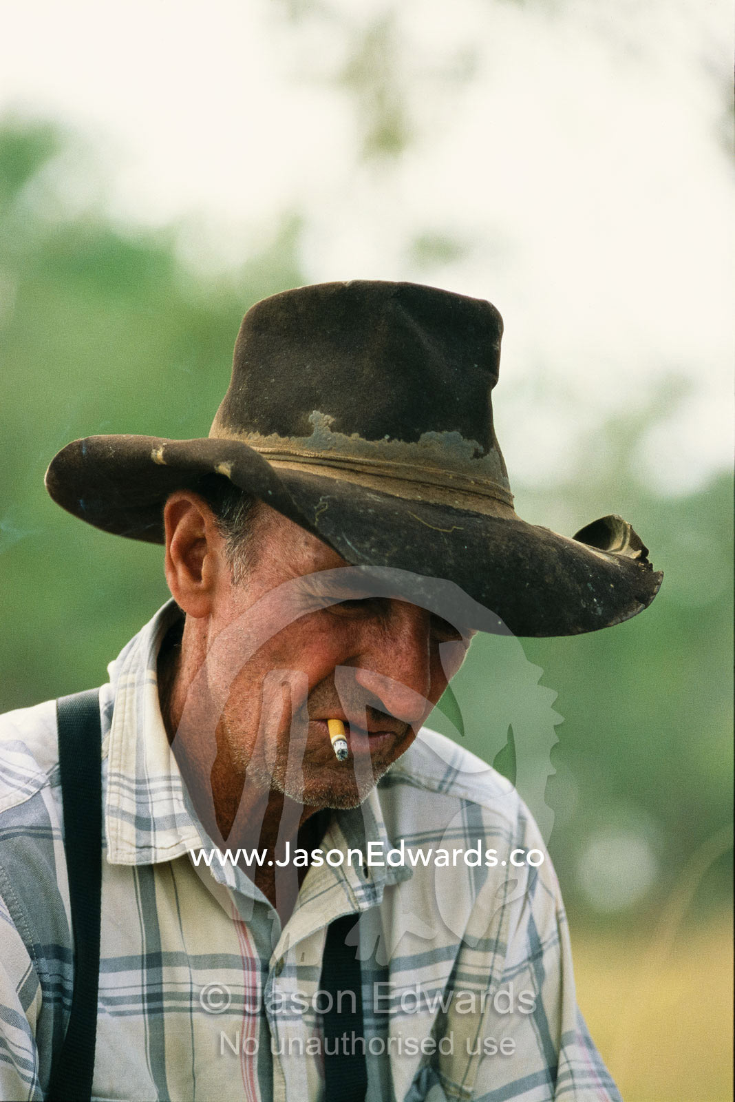 Cattle rancher with cigarette wearing a worn hat. Epping Forest Station, Queensland, Australia.