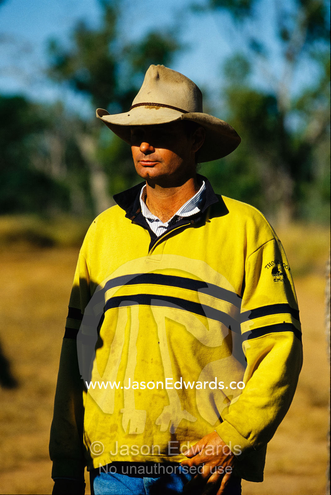 Helicopter pilot weraing a  yellow jacket and worn hat. Epping National Park, Queensland, Australia.