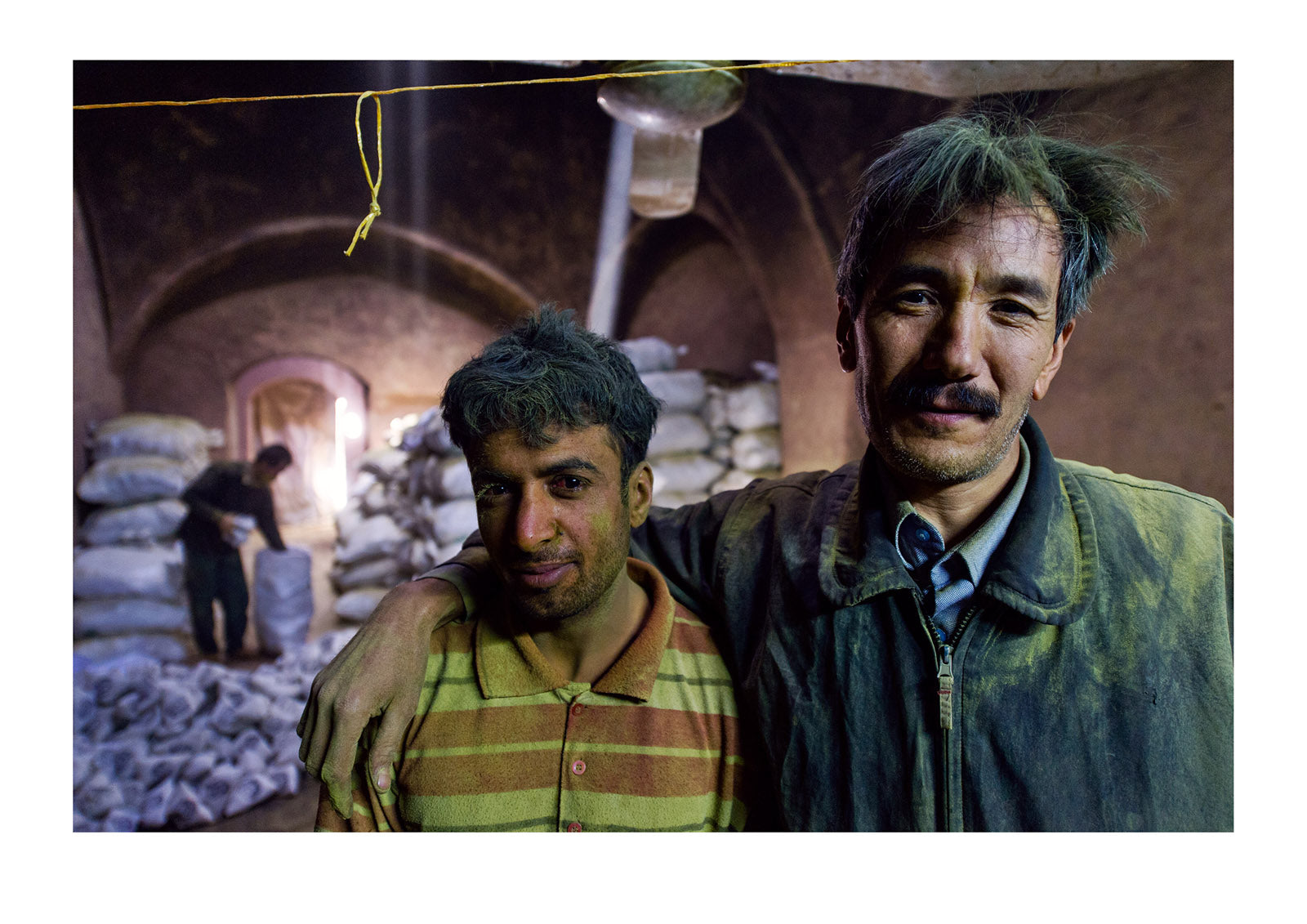 The exhausted faces of friends working in an ancient henna mill. Yazd, Yazd Province, Islamic Republic of Iran.