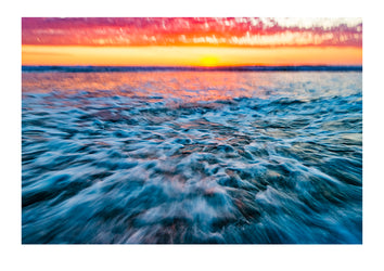 The blur of waves rushing onto a beach on an incoming tide at sunset. Venus Bay, Victoria, Australia.