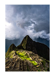 Machu Picchu. On a rain and mist filled day I decided to gamble my last hours to see if the sun would peer through a gap in the clouds. Minutes before the gates closed, I was given a single ray that illuminated the ancient ruins.  Peru.