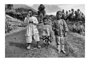Curious boys in a village greet hikers on their way to see endangered Mountain Gorillas.  Volcanoes National Park, Parc National des Volcans Rwanda.