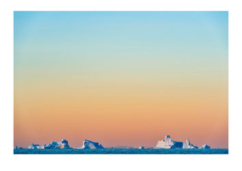 Pastel pink and purple lights Crevasse jagged icebergs rising from the arctic sea at sunset. Milne Land, Hall Bredning Fjord, Scoresby Sound, Greenland