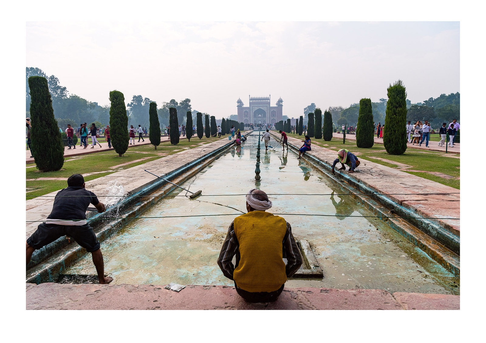 Labourers clean the reflection pool in the gardens of the Taj Mahal. Taj Mahal, Agra, India.