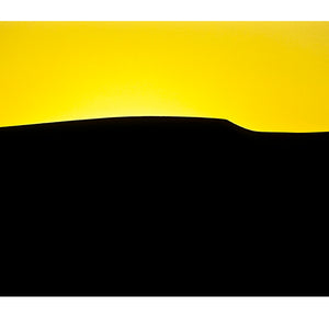The silhouette of a vast sand dune crest against a vivid yellow sky. near Sossusvlei, Great Southern Dune Field, Namib-Naukluft National Park, Namibia