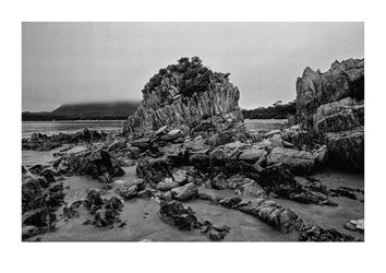 Stormy skies over a granite outcrop exposed at low tide. South West National Park, Tasmanian Wilderness World Heritage Area, Tasmania, Australia.
